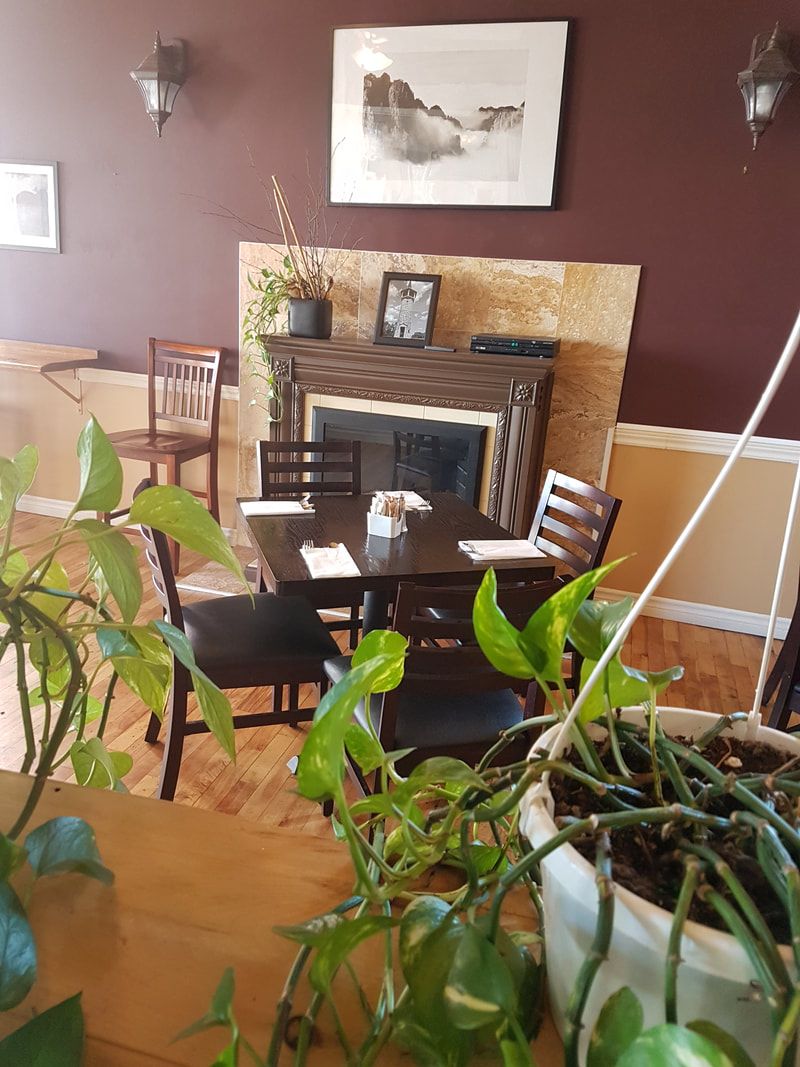 Dining room at Darlise Cafe with a fireplace and warm maroon walls